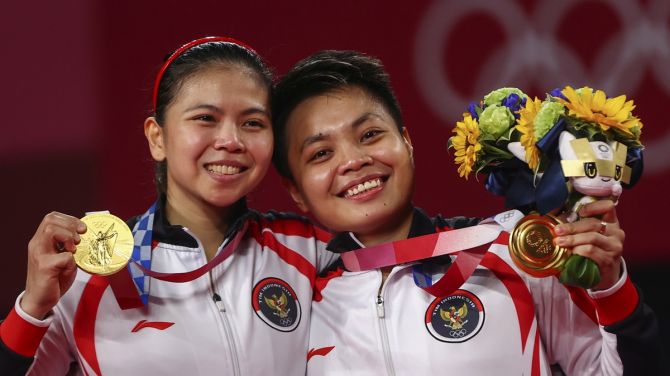 Indonesia's Greysia Polii and Apriyani Rahayu pose with their medals after winning the Tokyo Olympics women's doubles badminton gold