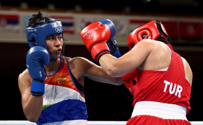 India's Lovlina Borgohain exchanges punches with Turkey's Busenaz Surmeneli (Red) during the Olympics women's Welterweight (64-69kg) boxing semi-final bout, at Kokugikan Arena in Tokyo, on Wednesday