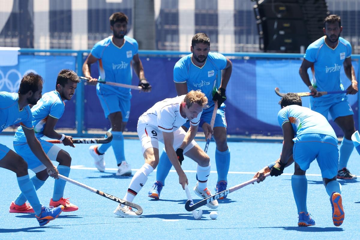 Germany's Niklas Wellen is challenged by a host of India defenders.