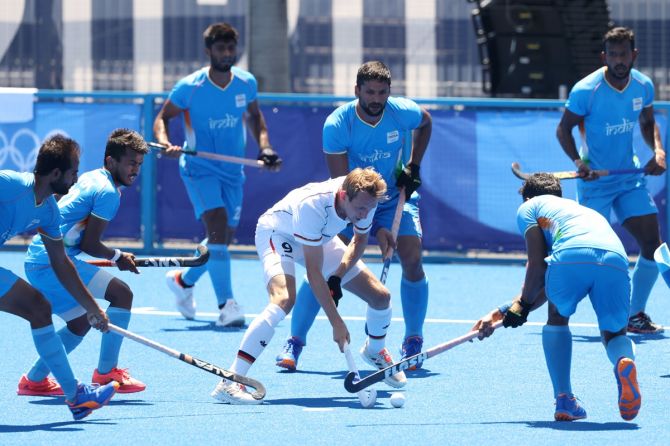 Germany's Niklas Wellen is challenged by a host of India defenders.