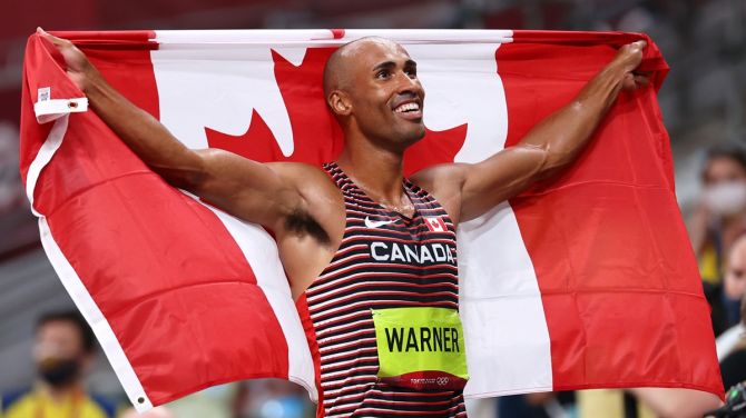 Canada's Damian Warner celebrates with his national flag after winning gold in the Olympics men's Decathlon.