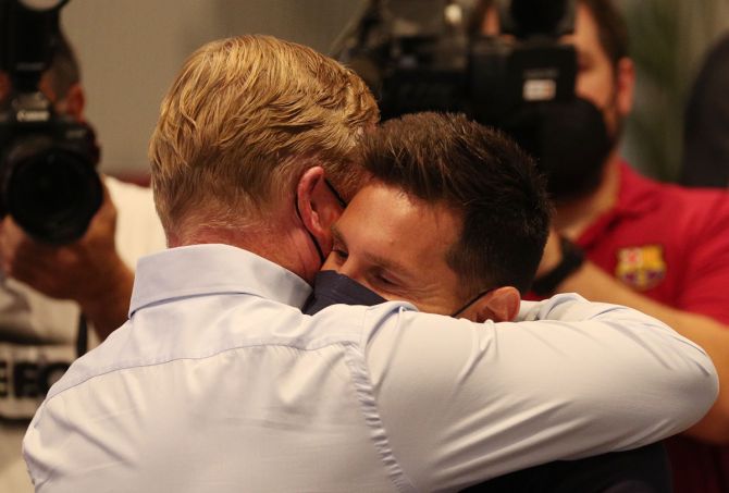 Lionel Messi gets a hug from Barcelona coach Ronald Koeman after the press conference.