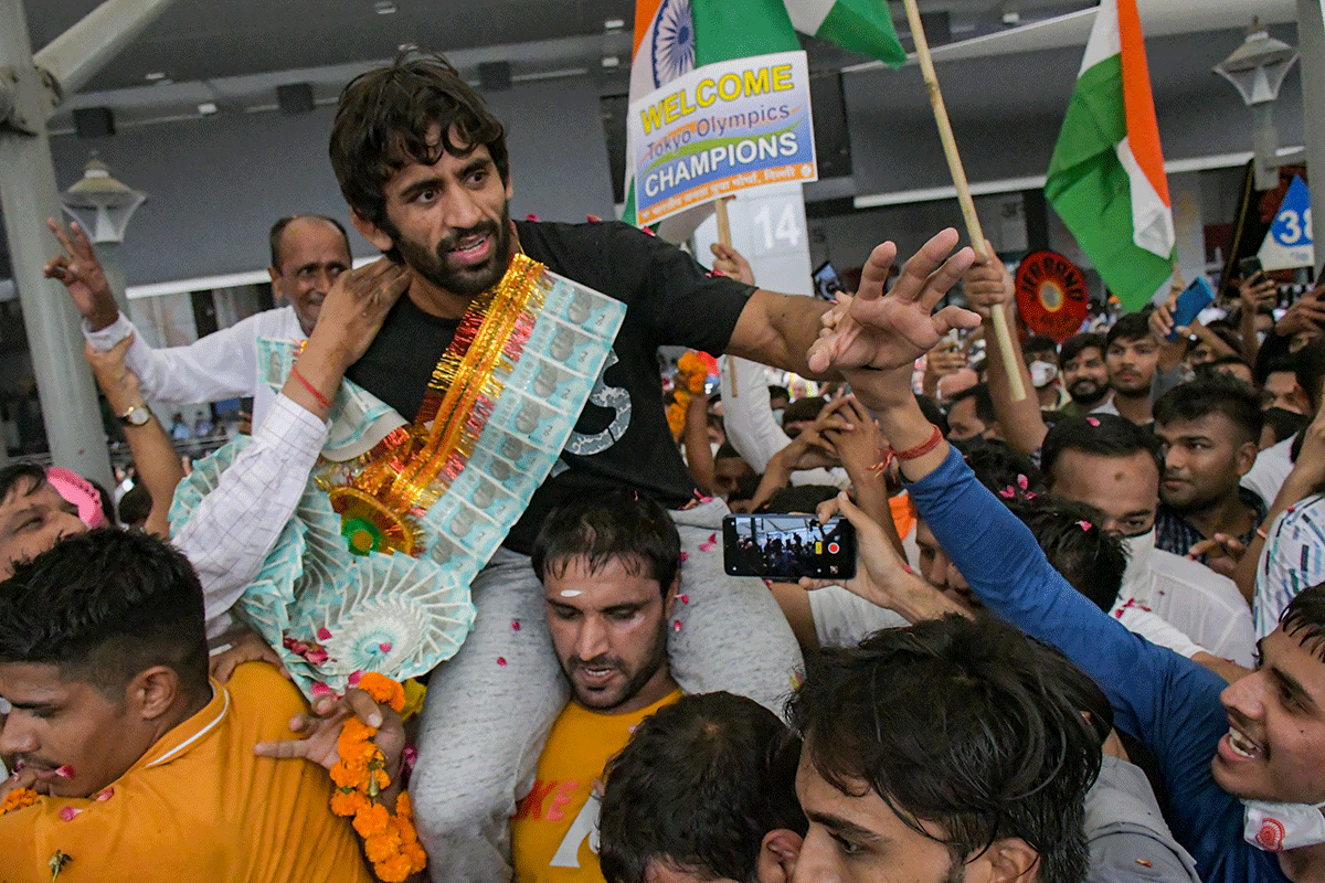 Bronze medallist wrestler Bajrang Punia is carried on the shoulders by a fan