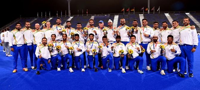 India’s Chief coach Graham Reid and the men’s hockey team pose with their bronze medals after the presentation ceremony at the Tokyo Olympics