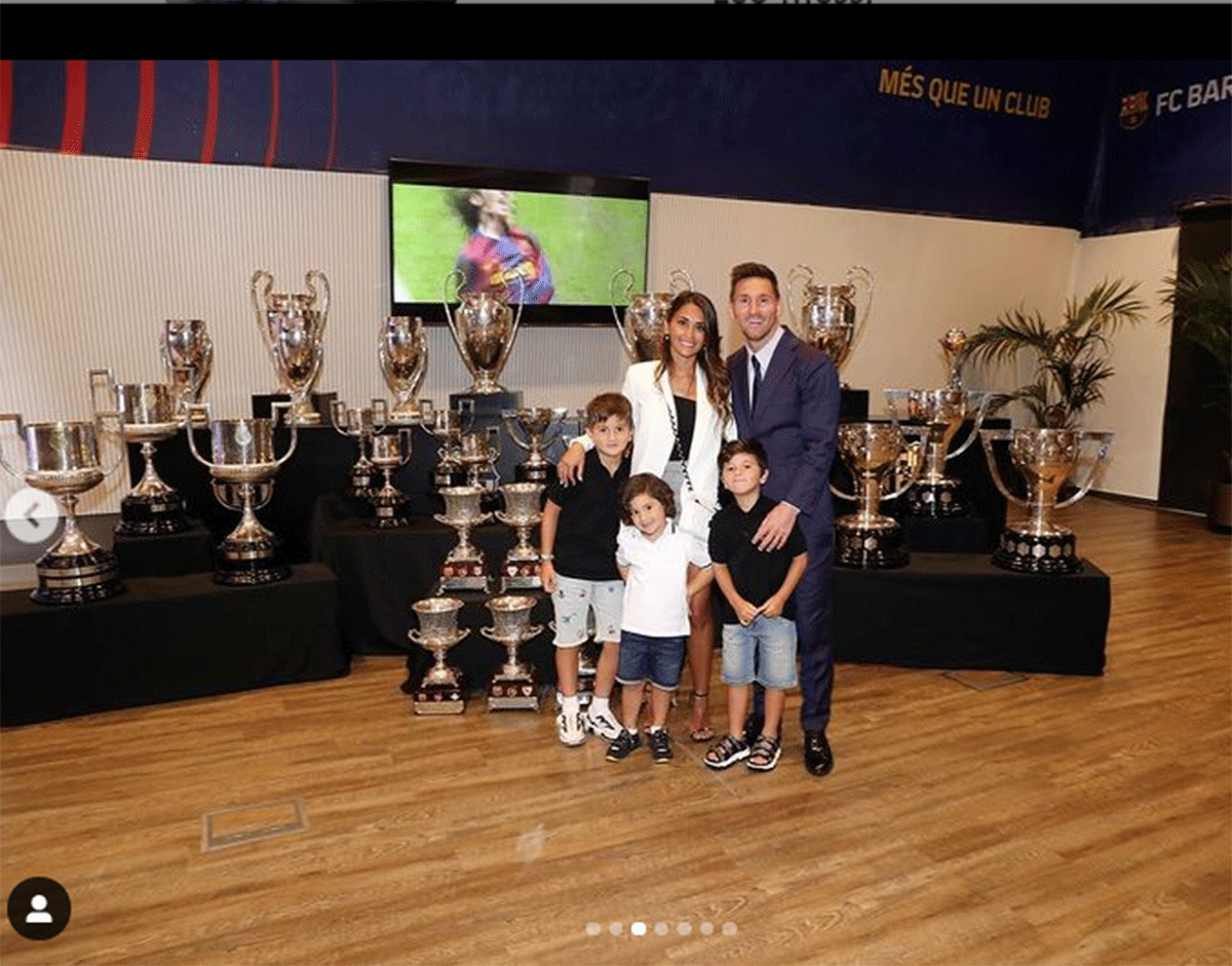 Lionel Messi and his family with his trophies in the background