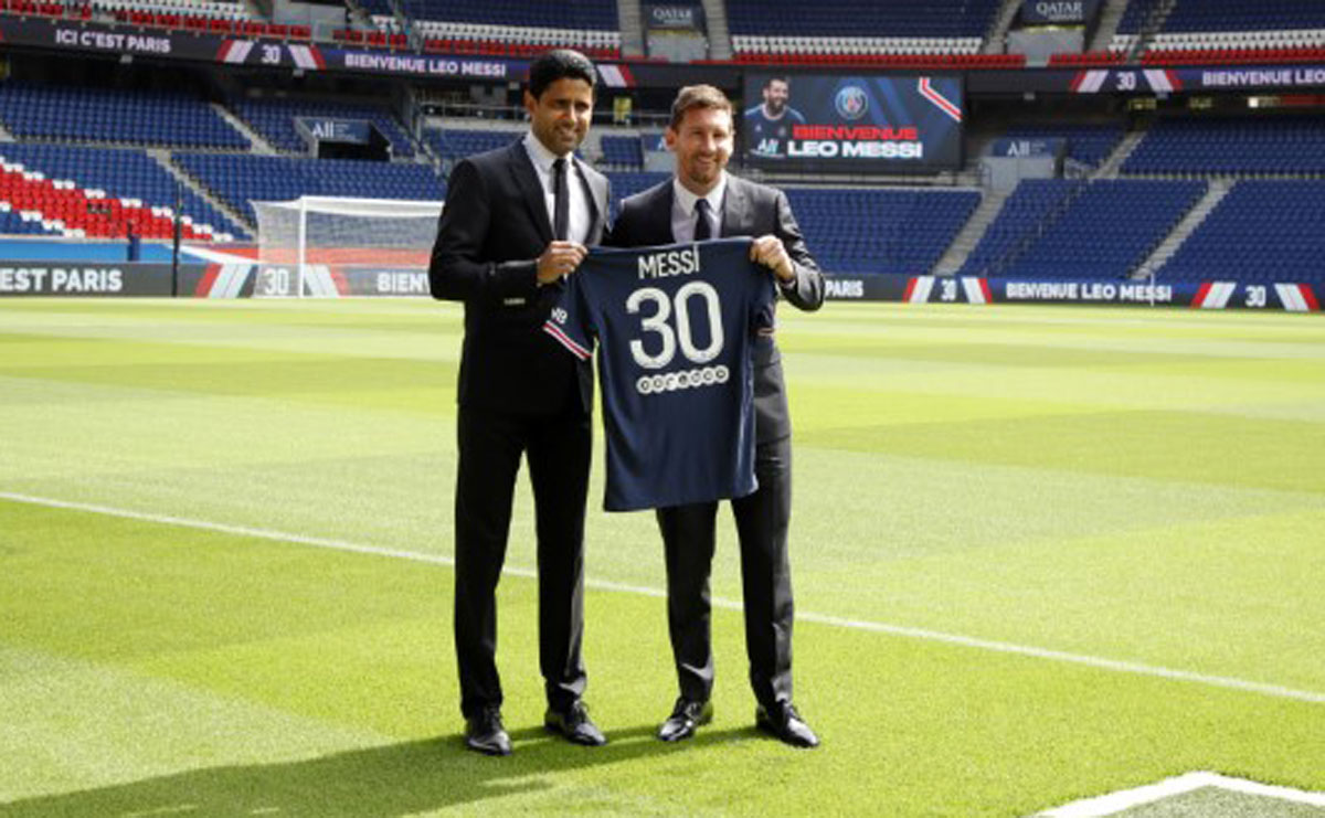 Argentinian football player Lionel Messi holds-up his number 30 shirt while  standing on the pitch during a press conference at the French football club Paris  Saint-Germain's (PSG) Parc des Princes stadium in