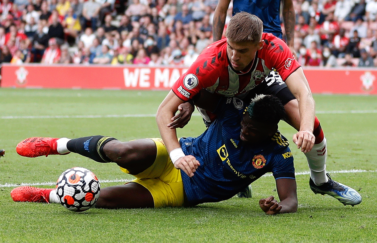 Manchester United's Paul Pogba takes a topple as he vies for possession with Southampton's Jan Bednarek 