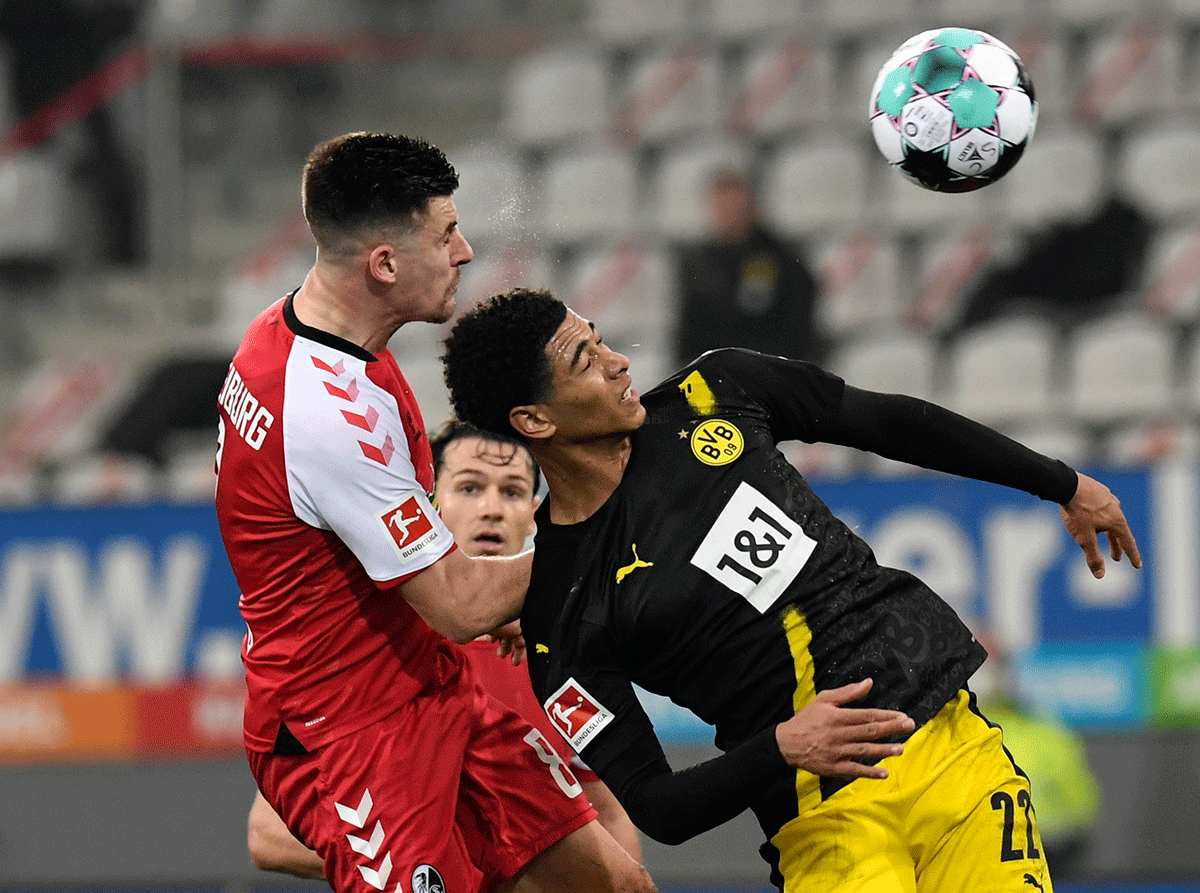 SC Freiburg's Baptiste Santamaria in action with Borussia Dortmund's Jude Bellingham during their Bundesliga match at Schwarzwald-Stadion, Freiburg, Germany.