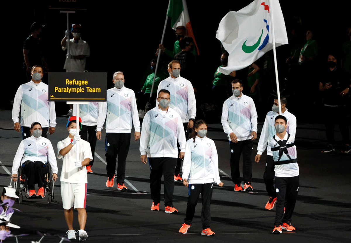 Flag bearers Alia Issa and Abbas Karimi of Refugee Paralympic Team lead their delegation in the parade of athletes during the opening ceremony
