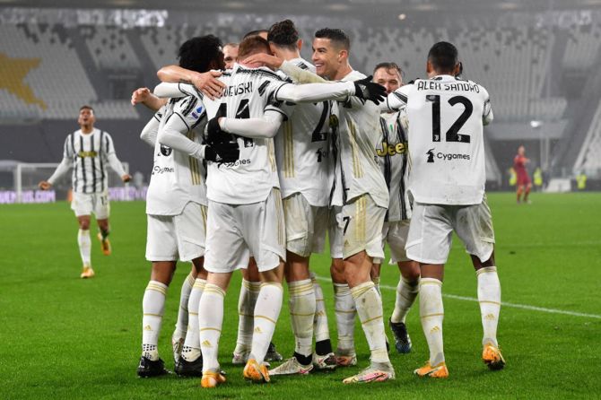 Juan Cuadrado, Dejan Kulusevski, Alex Sandro, and Cristiano Ronaldo celebrate following Juventus's second strike, an own goal by Ibanez of AS Roma (not pictured). 