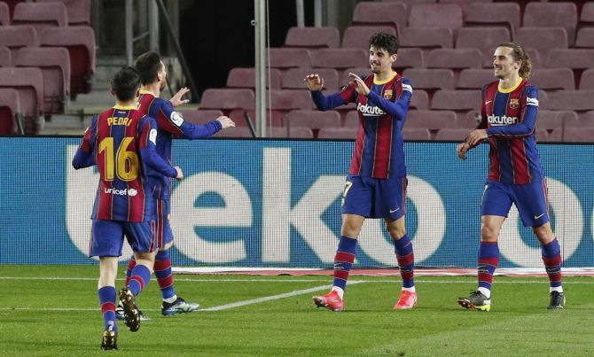 Francisco Trincao celebrates scoring Barcelona's third goal with teammates. 