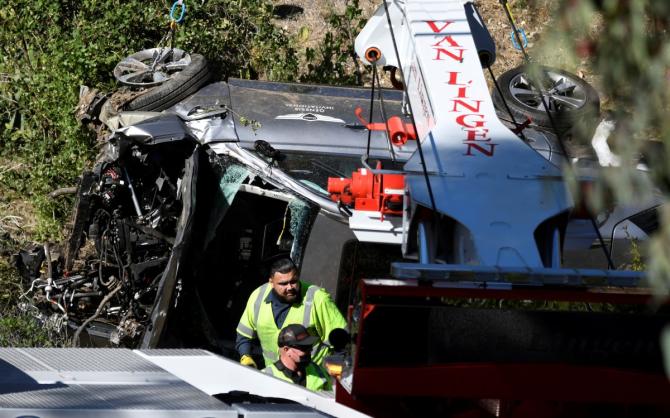 The severely damaged vehicle of golfer Tiger Woods is lifted by a crane