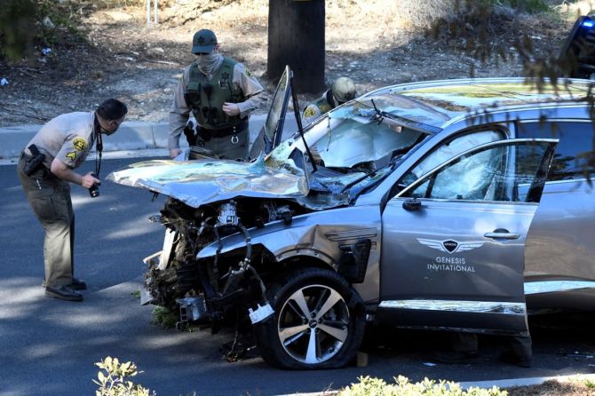 Los Angeles County Sheriff's Deputies inspect the vehicle of golfer Tiger Woods, who was rushed to hospital after suffering multiple injuries, after it was involved in a single-vehicle accident in Los Angeles, California on Tuesday