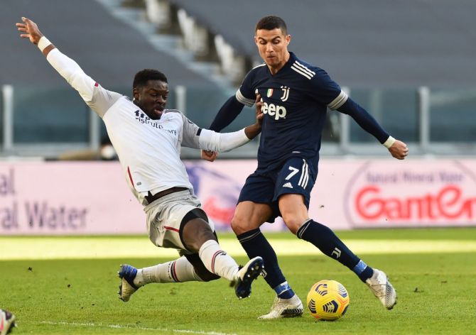 Juventus' Cristiano Ronaldo vies for possession with Bologna's Adama Soumaoro during their Serie A match at Allianz Stadium, Turin, Italy.