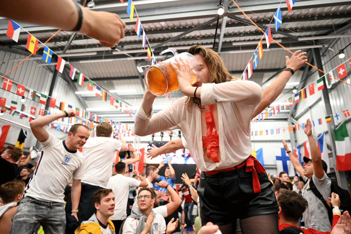 England fans celebrate as they watch a live broadcast of the semi-final match between England and Denmark at Hackney Bridge