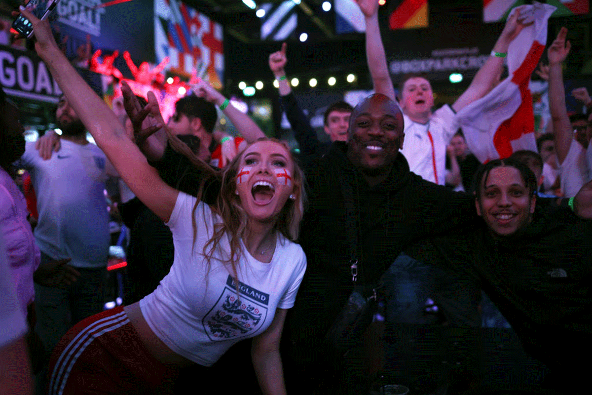 England fans cheer at BOXPARK Croydon as they watch a live broadcast of the semi-final match between England and Denmark