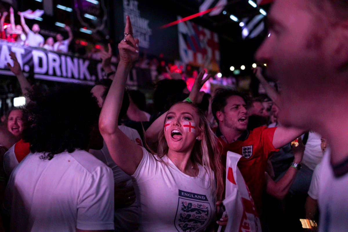 England fans cheer at BOXPARK Croydon as they watch a live broadcast of the semi-final match between England and Denmark 