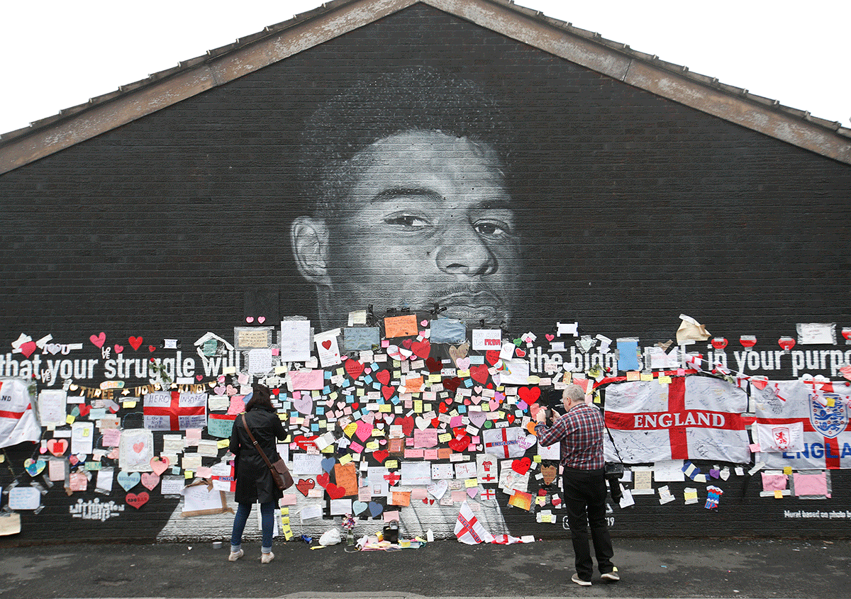 A mural of Marcus Rashford in Withington, Manchester is covered with messages of support on Tuesday, a day after it was defaced following the Euro 2020 final between Italy and England.