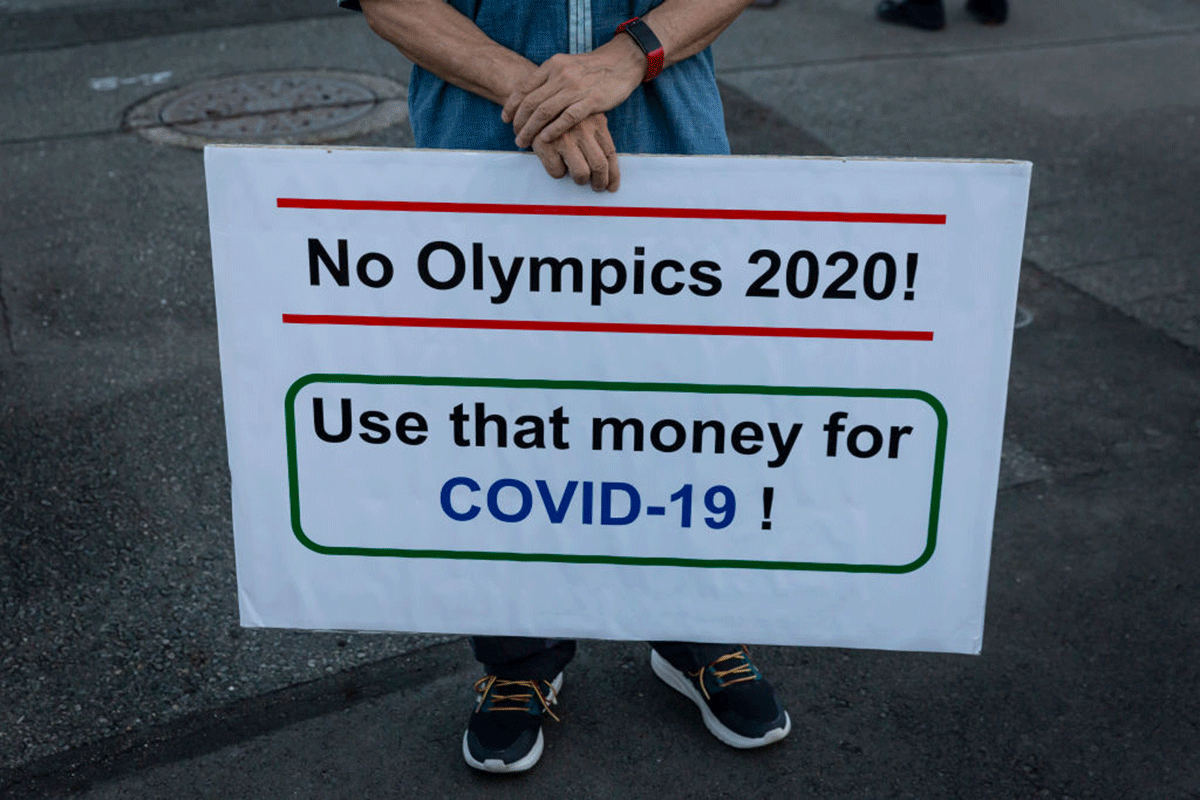 A protester holds a placard during a demonstration against the forthcoming Tokyo Olympic Games in Tokyo on Friday