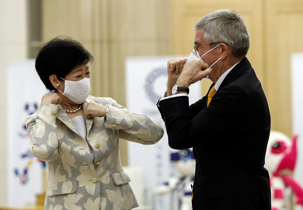 Tokyo Governor Yuriko Koike and Thomas Bach, President of the International Olympic Committee (IOC), bump elbows at the start of their talks at Tokyo Metropolitan Government Office Building in Tokyo, on Friday