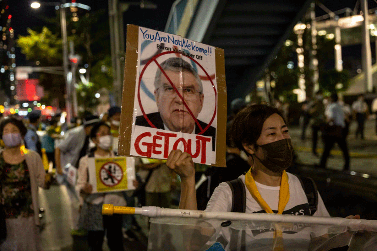 A protester holds a placard with a picture of International Olympic Committee President Thomas Bach during a demonstration against the forthcoming Tokyo Olympic Games in Tokyo on Friday. Protesters gathered to demonstrate against International Olympic Committee President Thomas Bach’s visit to Hiroshima amid concern over the safety of holding the Games during the global coronavirus pandemic
