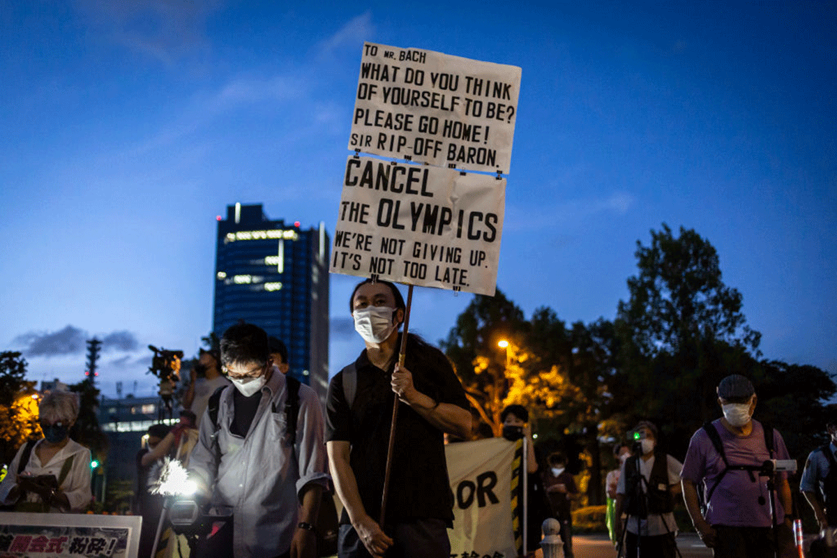 A protester holds a placard during a demonstration against the forthcoming Tokyo Olympic Games