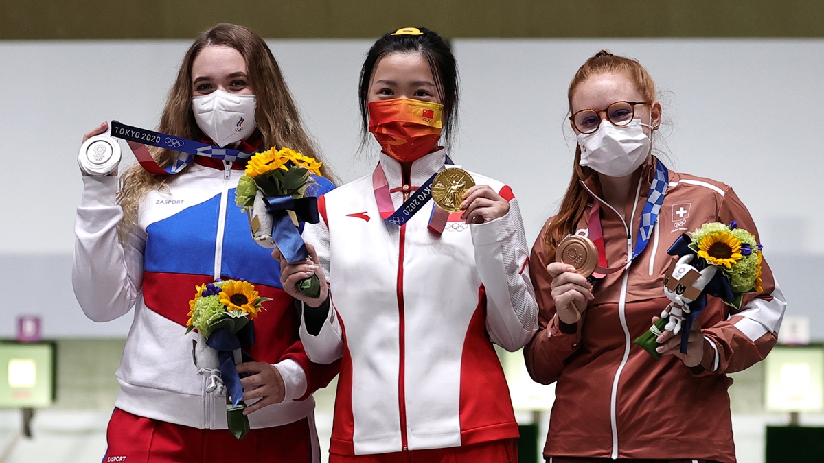 Gold medallist Yang Qian of China celebrates with silver medallist, Anastasiia Galashina of the Russian Olympic Committee and bronze medallist Nina Christen of Switzerland after the women's 10m Air Rifle medal ceremony.
