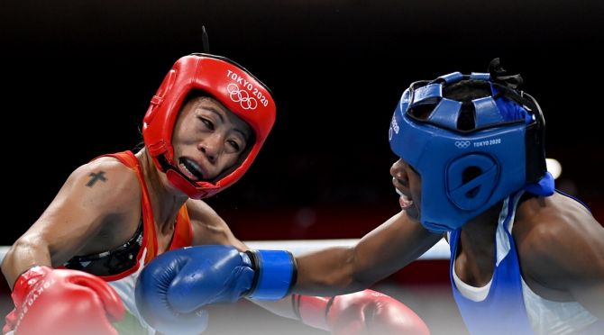Mary Kom, in red, takes evasive action against a punch from Miguelina Hernandez Garcia