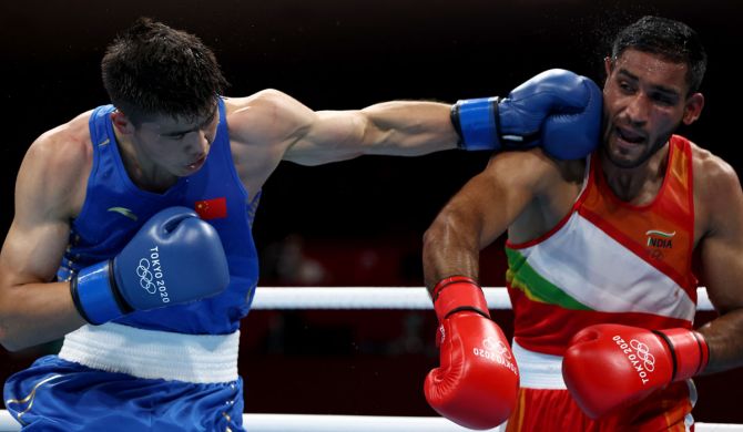 India's Ashish Kumar, right, exchanges punches with China's Erbieke Tuoheta during the men's middleweight (69-75kg) Tokyo Olympics bout, at Kokugikan Arena, on Monday.