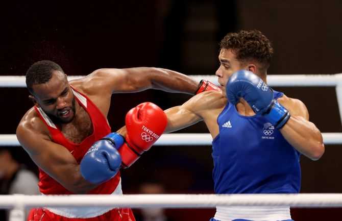 Morocco's Youness Baalla (red) and New Zealand's David Nyika exchange punches during the men's heavyweight (81-91kg) bout at the Tokyo Olympics