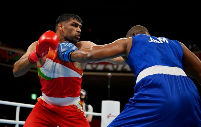 India's Satish Kumar in action against Jamaica's Ricardo Brown during the Olympics boxing men's Super Heavyweight last 16 bout