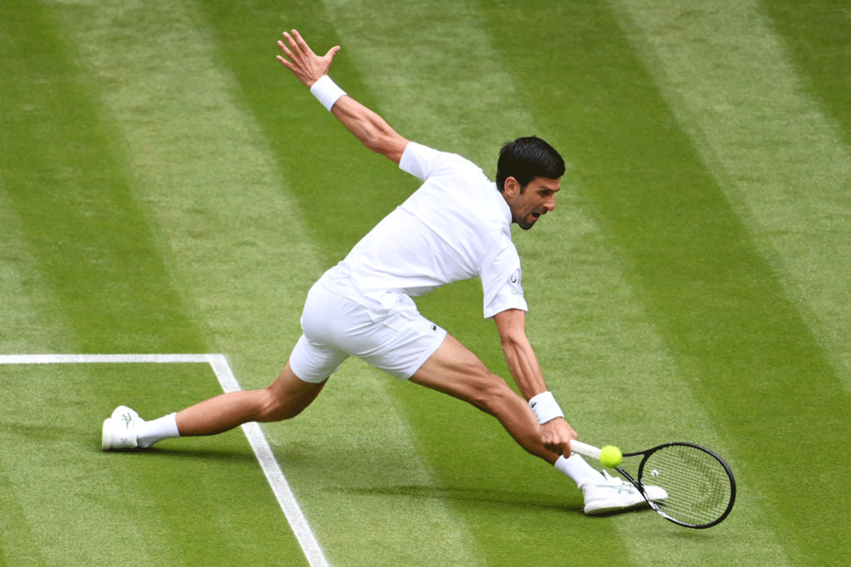 Novak Djokovic stretches to play a backhand against Kevin Anderson during their Wimbledon second round match on Wednesday