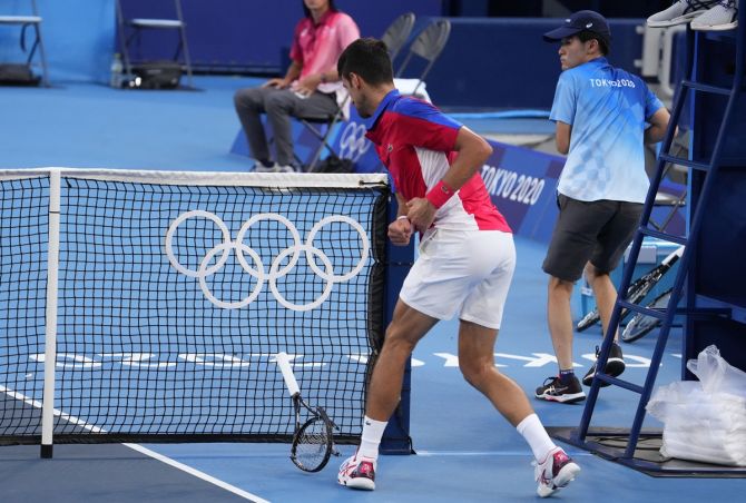Novak Djokovic breaks his racket during the third set against Pablo Carreno Busta.