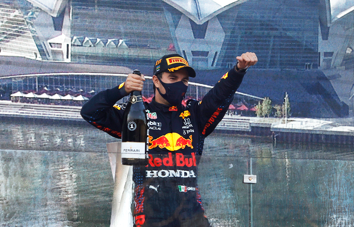 Red Bull's Sergio Perez celebrates with sparkling wine on the podium after winning the race