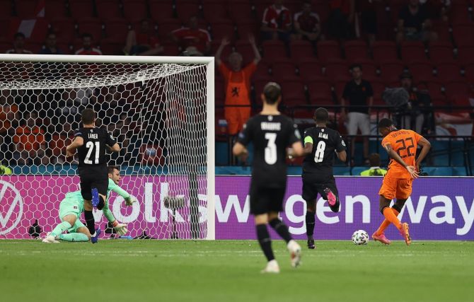 Denzel Dumfries sends the ball past Austria's Daniel Bachmann for the Netherlands's second goal 