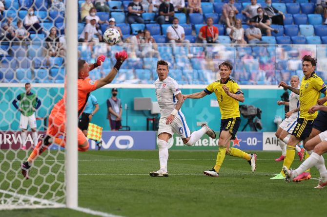 Sweden goalkeeper Robin Olsen saves a shot from Slovakia's Juraj Kucka (No. 19)