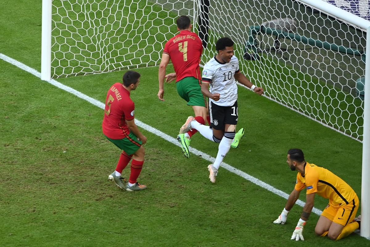 Serge Gnabry celebrates Germany's second goal, as Portugal's Raphael Guerreiro deflects the ball into his own net