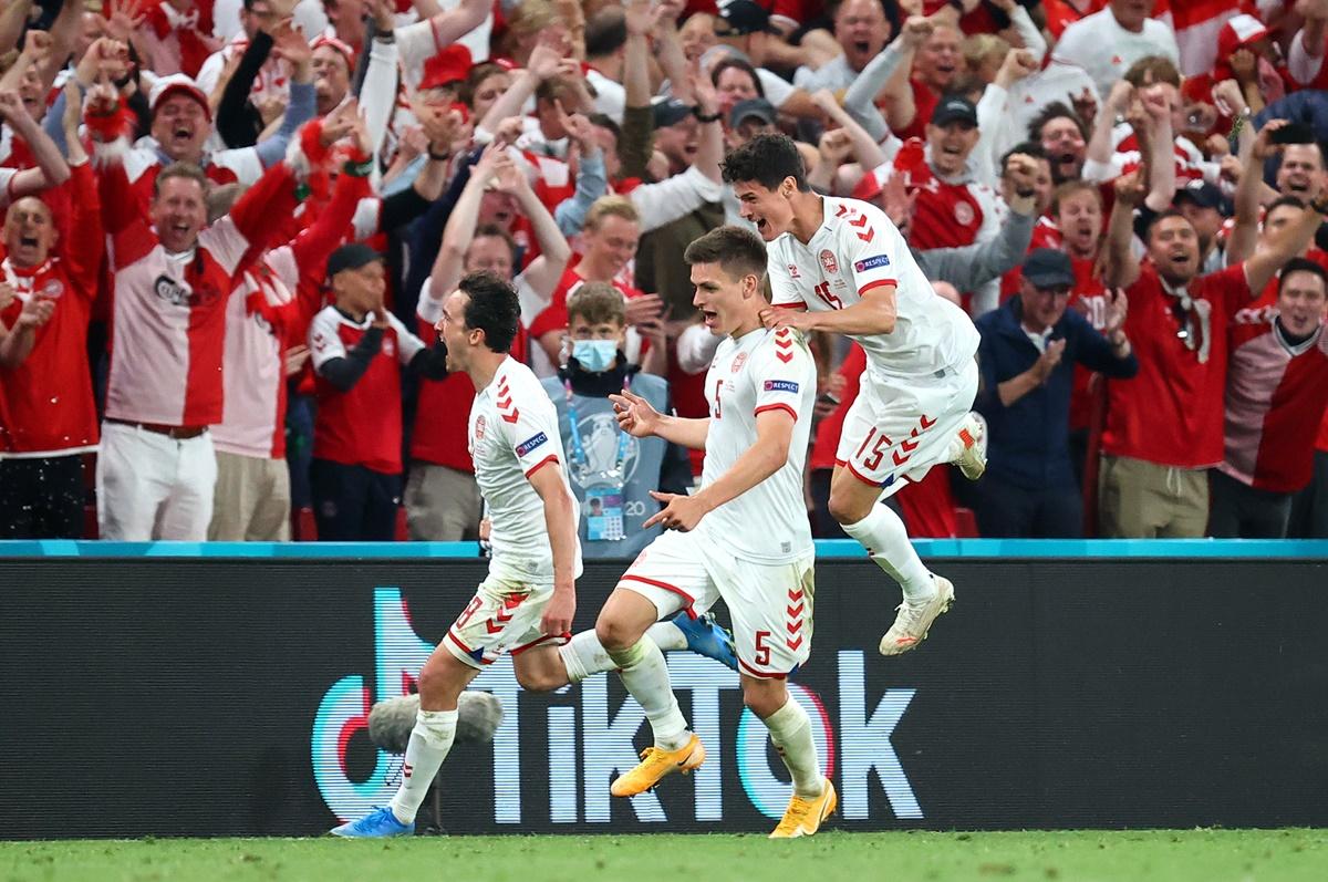 Joakim Maehle celebrates with teammates Thomas Delaney and Christian Norgaard after scoring Denmark's fourth goal.