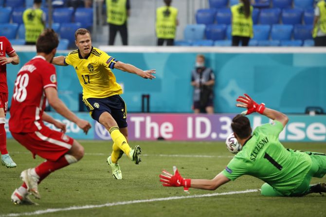 Viktor Claesson scores Sweden's third goal past Poland goalkeeper Wojciech Szczesny in added time