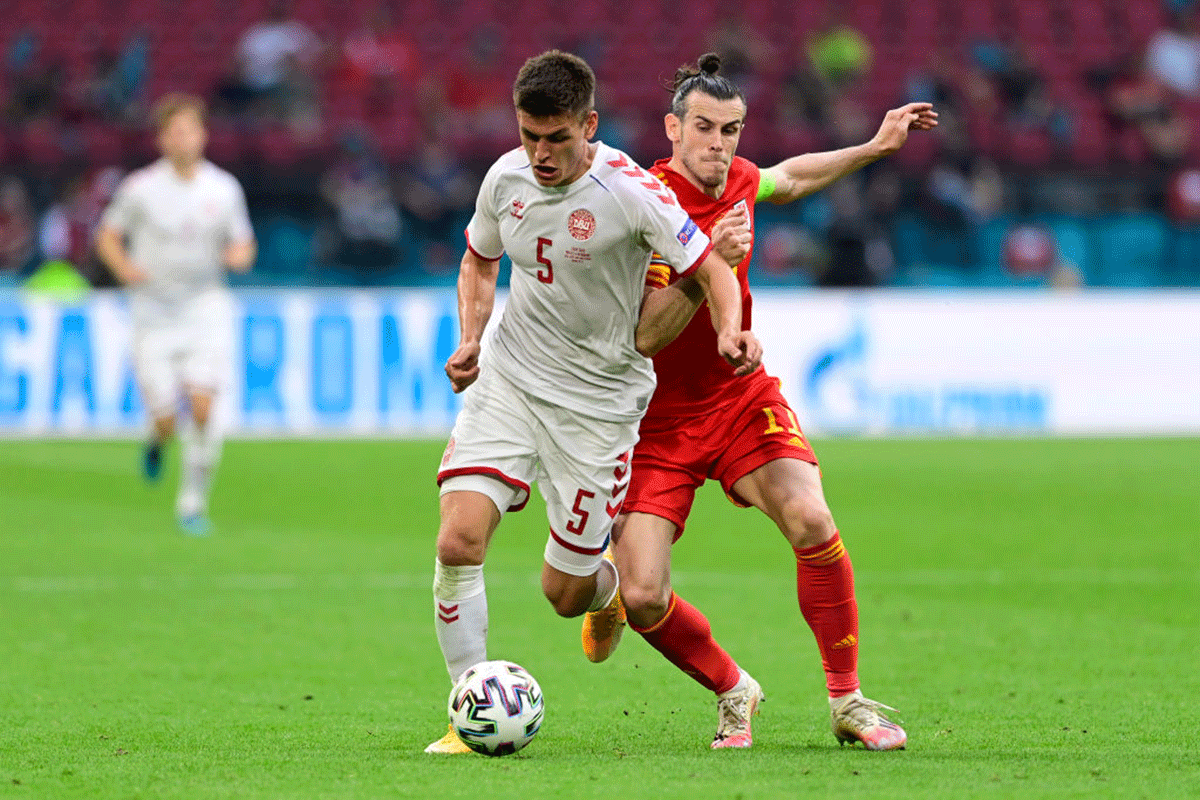 Denmark's Joakim Maehle is challenged by Wales' Gareth Bale