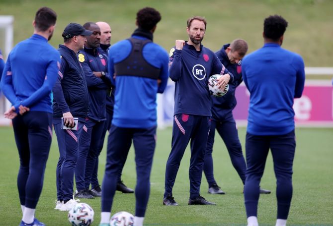England coach Gareth Southgate talks to players during training