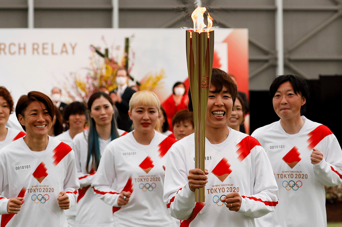 Tokyo 2020 Olympic Torch Relay Grand Start torchbearer Nadeshiko Japan, Japan's women's national soccer team, leads the torch relay in Naraha, Fukushima prefecture, in Japan on March 25, 2021.