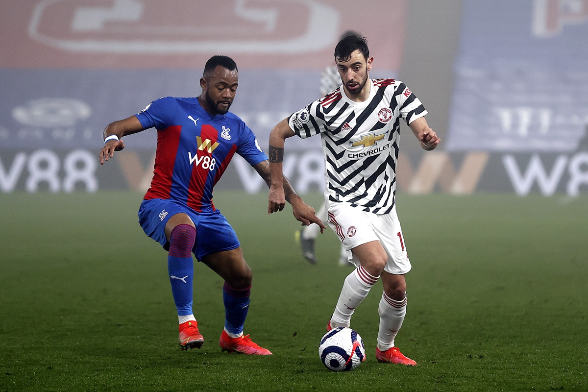Manchester United's Bruno Fernandes battles for possession with Crystal Palace's Jordan Ayew.