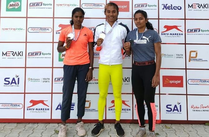 Hima Das, centre, S Dhanalaxmi, left, and Archana Suseendran show off their medals after the women's 200 metres