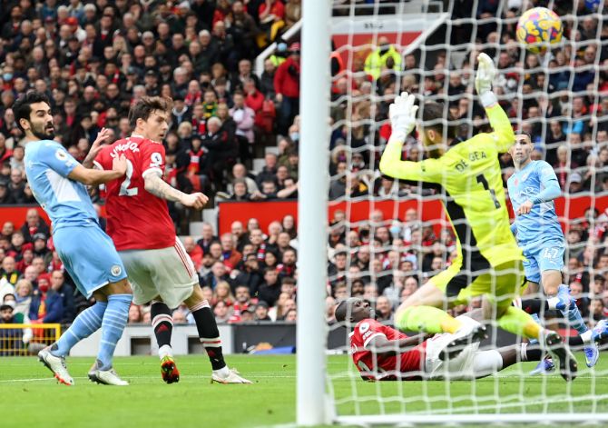 Manchester United defender Eric Bailly, on ground, turns a low Joao Cancelo cross into his own net to give Manchester City the lead