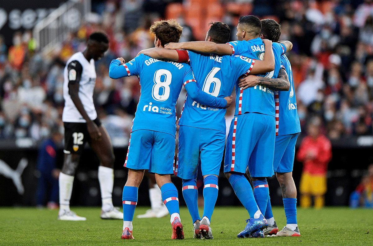 Atletico Madrid's Antoine Griezmann, Koke and Luis Suarez celebrate after Sime Vrsaljko scores their third goal against Valencia in the La Liga at Mestalla, Valencia, Spain