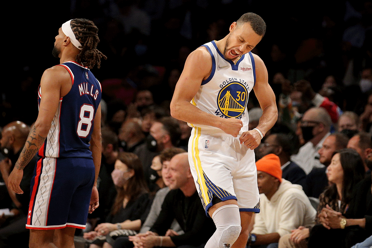Golden State Warriors guard Stephen Curry (30) reacts in front of Brooklyn Nets guard Patty Mills (8) after scoring a basket during the fourth quarter of their NBA match at Barclays Center in Brooklyn, New York on Monday. 