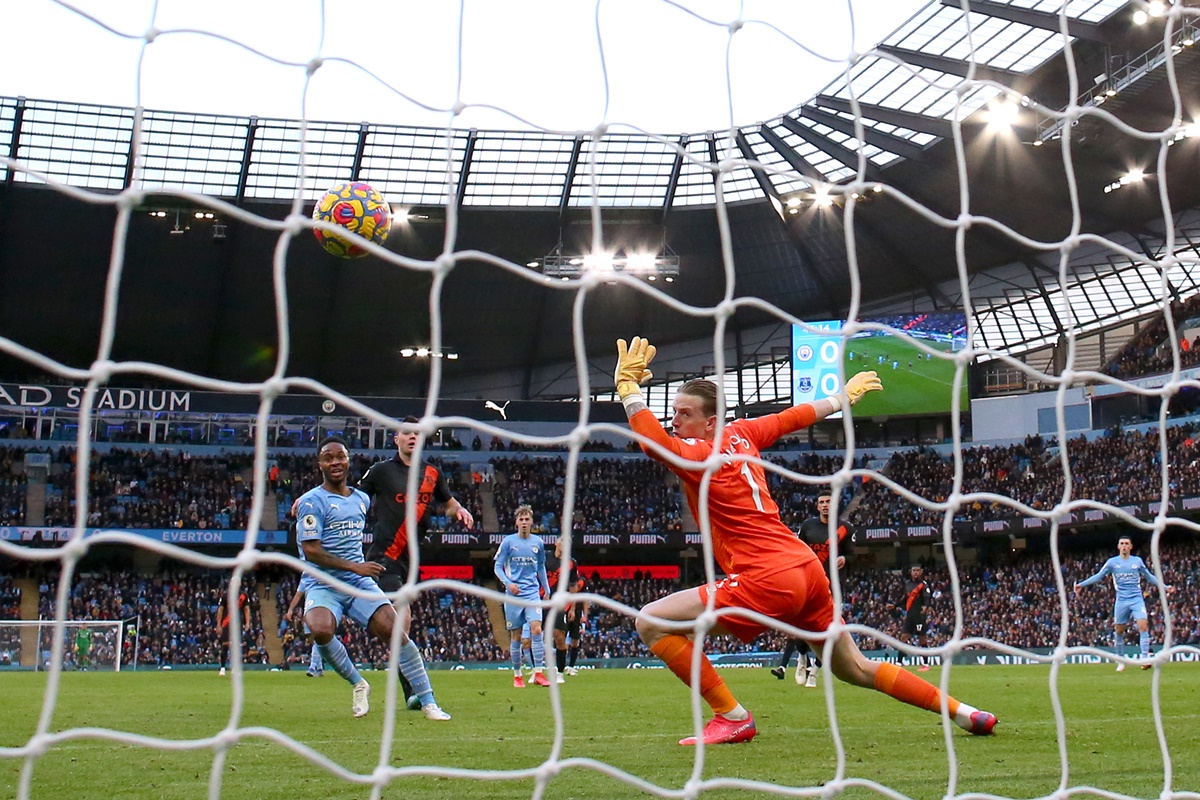 Raheem Sterling scores past goalkeeper Jordan Pickford to put Manchester City ahead during the Premier League match against Everton, at Etihad Stadium in Manchester, England, on Sunday.