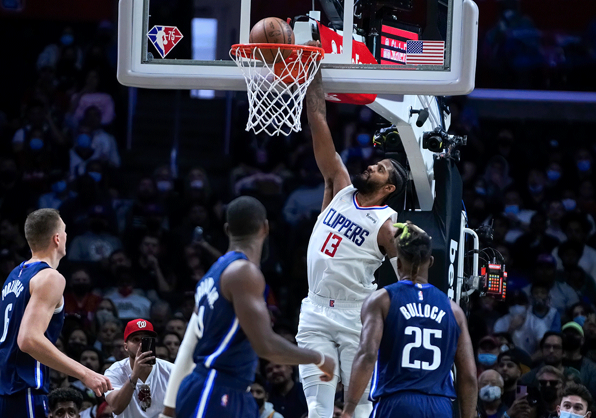 LA Clippers guard Paul George (13) slams dunks past Dallas Mavericks center Kristaps Porzingis (6), forwards Tim Hardaway Jr. (11) and Reggie Bullock (25) in the fourth quarter of their NBA match at Staples Center in Los Angeles, California, on Sunday