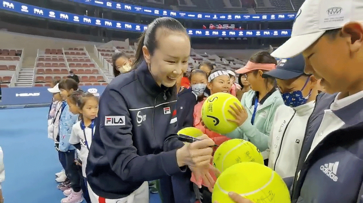 Chinese tennis player Peng Shuai signs large-sized tennis balls at the opening ceremony of Fila Kids Junior Tennis Challenger Final in Beijing, China on Saturday, in this screen grab obtained from a social media video.